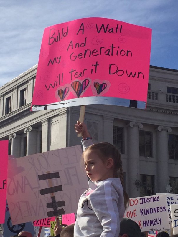 democrat - child holding sign saying build a wall and my generation will tear it down